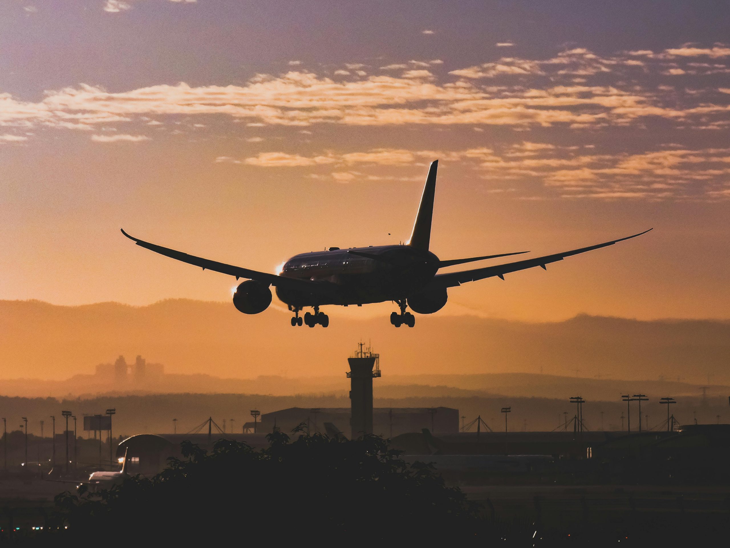 Free White Passenger Plane Flying over the City during Sunset Stock Photo