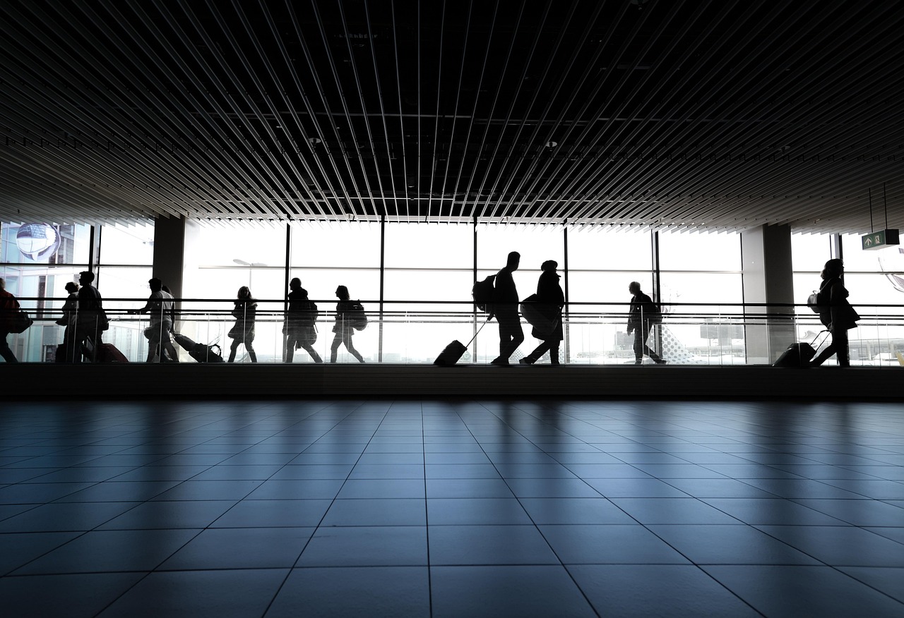 Airline Pilot Interview Questions and Answers (2026 Guide) 2 Travelers walking through an airport terminal near large windows