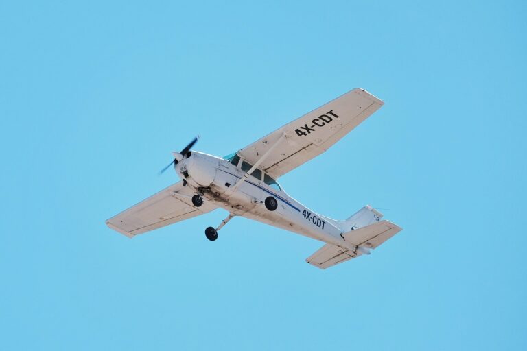 A Cessna 172 training aircraft climbing against a clear blue sky