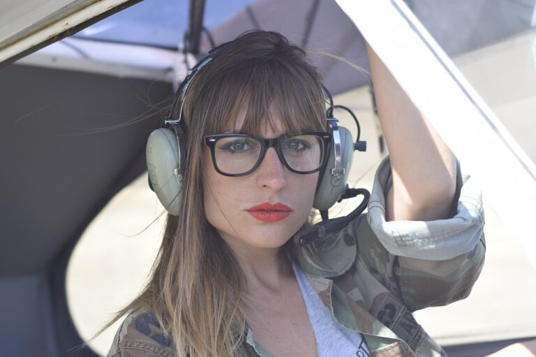 Part 61 vs Part 141: Which Flight Training Path Should You Choose? Student pilot wearing a headset and glasses at the controls of a small training aircraft